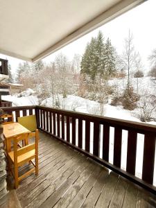 a balcony with a table and a view of a snow covered field at Studio Cosy avec balcon in Combloux