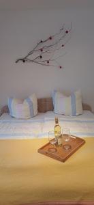 a tray with two glasses and a bottle of wine on a bed at Hauptstraße 19 in Zachenberg