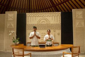 a man and a woman standing in front of a table at Adiwana Alas Harum in Ubud