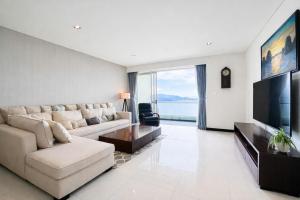 a living room with a couch and a flat screen tv at Sea View Luxury - Apartments in Nha Trang