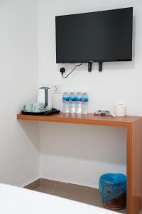 a shelf with bottles of water and a flat screen tv at TEBRAU 11 Guesthouse in Johor Bahru
