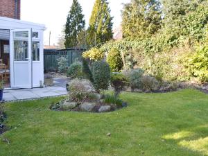 a garden with a white door and some plants at Pam's Plaice in Offord Cluny