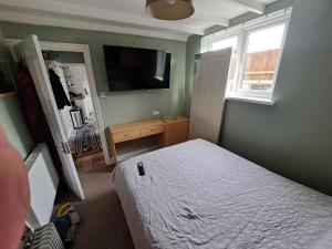 a bedroom with a bed and a television in it at The Old Chip Shop in Ilchester