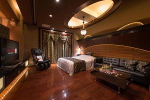 a bedroom with a bed and a couch and a tv at ホテルルアン横浜 in Kikuna