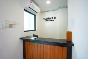 a reception desk in an office with a sign on the wall at TEBRAU 11 Guesthouse in Johor Bahru