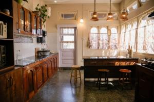 a kitchen with wooden cabinets and a large island with stools at Meizies Home in Shillong