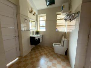 a bathroom with a white toilet and a sink at Meizies Home in Shillong