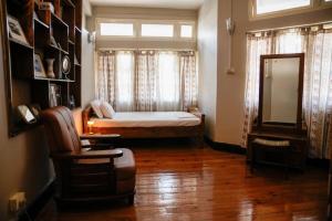 a bedroom with a bed and a window and a chair at Meizies Home in Shillong +3 photos