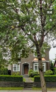 a house with a tree in front of it at Moon rooms in Vancouver