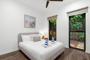 a white bed in a room with a window at Belle Escapes Samaya in Palm Cove +41 photos