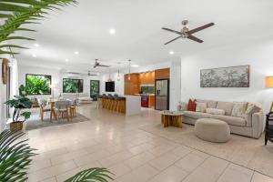 a living room and dining room with a ceiling fan at Belle Escapes Samaya in Palm Cove