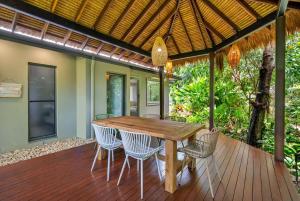 a wooden table and chairs on a deck at Belle Escapes Samaya in Palm Cove