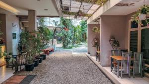 a hallway of a house with plants and tables at C Family Hotel in Citeureup 1