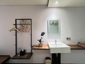 a bathroom with a white sink and a mirror at C Family Hotel in Citeureup 1 +134 photos