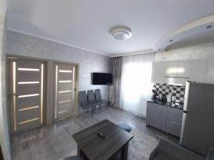 a living room with a table and a kitchen with a television at Tom House Garden in Tsaghkadzor