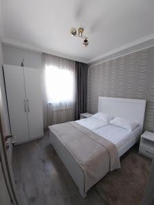 a bedroom with a white bed and a window at Tom House Garden in Tsaghkadzor