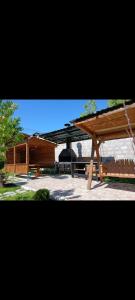 a wooden pavilion with a building in the background at Tom House Garden in Tsaghkadzor