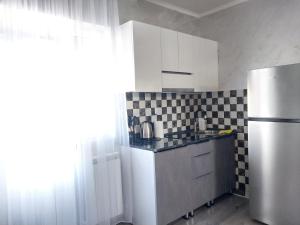 a kitchen with a refrigerator and black and white tiles at Tom House Garden in Tsaghkadzor