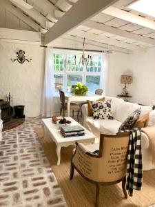 a living room with a white couch and a table at ONE WEE COTTAGE Bring your dog and enjoy a cosy romantic winter fireside stay in Healesville