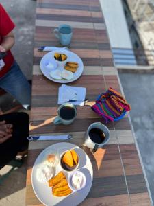 ein Tisch mit zwei Tellern Essen und Tassen Kaffee in der Unterkunft Hotel Henderson in San Pedro La Laguna