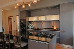 a kitchen with a bar with chairs and a sink at Stone Heaven Villa in Nuwara Eliya