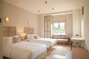 a bedroom with two beds and a couch and a window at Stone Heaven Villa in Nuwara Eliya