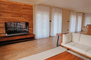a living room with a white couch and a television at Stone Heaven Villa in Nuwara Eliya