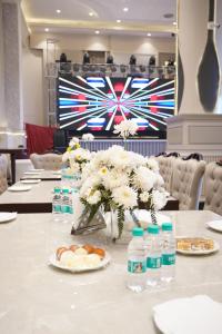 a table with white flowers and bottles of water at Hotel The Grand Mirage in Bathinda