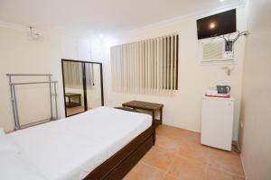 a bedroom with a bed and a small refrigerator at El Centro Beach Resort Boracay in Boracay +7 photos