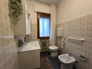 a bathroom with a sink and a toilet and a window at CA'venezia in Mestre