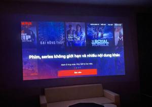 a flat screen tv on a wall with a couch at Mai Ve Home in Lương Xâm
