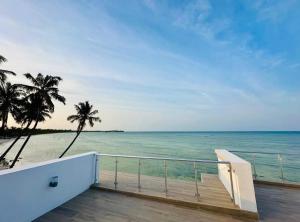 a balcony with a view of the ocean and palm trees at Bahari Beach Front Villa in Mdudu Mkubwa