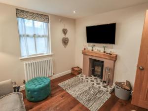 a living room with a fireplace and a flat screen tv at West View in Milnthorpe