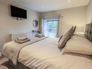 a bedroom with a large bed with towels on it at West View in Milnthorpe