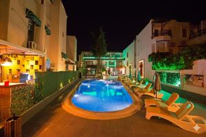 a swimming pool with lounge chairs and a hotel at night at Casa Blue Hotel All Inclusive in Bodrum City
