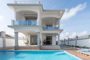 a house with a swimming pool in front of a house at Bahari Beach Front Villa in Mdudu Mkubwa