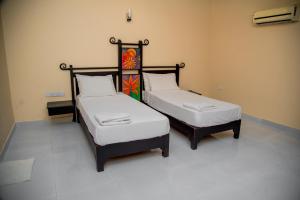 two beds sitting next to each other in a room at Lavendish Country Resort in Dambulla +19 photos