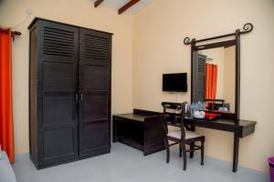 a room with a desk and a door and a mirror at Lavendish Country Resort in Dambulla