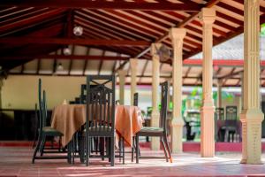 a table and chairs with a table cloth on it at Lavendish Country Resort in Dambulla