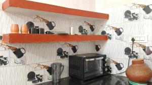a microwave sitting on a counter in a kitchen at Arav Homestay in Rishīkesh