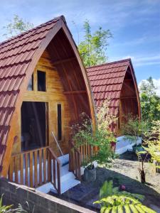 a small wooden cabin with a large door and a porch at SKY SUNSET Bungalows in Tetebatu