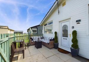 a patio with a couch and chairs next to a house at Sea Breeze Holiday Chalet in Bridlington +20 photos
