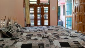 a bed with a quilt on it in a bedroom at Arav Homestay in Rishīkesh +2 photos
