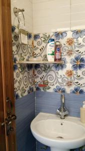a bathroom with a sink and blue and white tiles at Arav Homestay in Rishīkesh