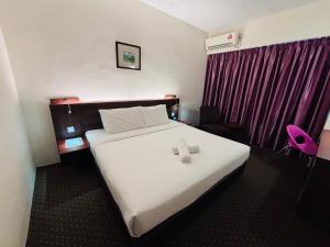 a hotel room with a bed with a towel on it at Hotel Yt Midtown Kuala Terengganu in Kuala Terengganu