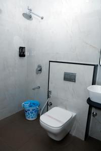 a bathroom with a toilet and a sink at Pearl Inn in Dhārwād +8 photos