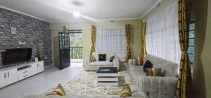 a living room with two couches and a tv at countrysidegatewayapartments in Nyeri