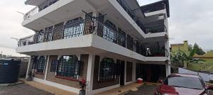 a white building with a balcony and a red car at countrysidegatewayapartments in Nyeri