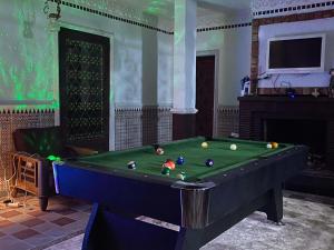 a pool table with balls on it in a room at Beau Riad de 3 chambres avec piscine à la rte d'Ourika in El Jemʼa Ghemat
