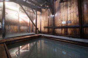 a swimming pool in a wooden building with wooden walls at Yachi Onsen in Towada +93 photos